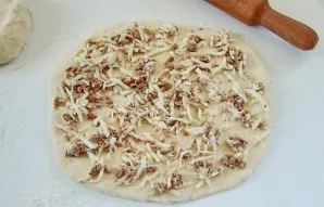 Divide the dough into 2-3 parts. Roll out each on a floured surface, about 3 mm thick. Spread the filling in a thin layer.