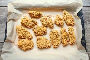 Put a baking sheet with nuggets in a hot oven and bake at a temperature of 180 degrees for 25 minutes until cooked. Remove the baking she...