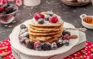 Spread the prepared pancakes on a plate, lay out the berries and sprinkle with a sweetener crushed with a coffee grinder.
