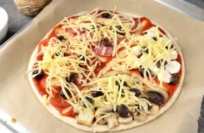 Finally, sprinkle the whole pizza with grated hard cheese and put it in a heated oven for 10-12 minutes at a temperature of 200 degrees.