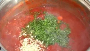 After boiling, add chopped herbs and garlic to the pan.