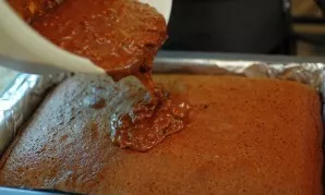 Remove the cake from the oven and leave to cool for a few minutes, then pour the warm cake with icing and leave to cool completely.