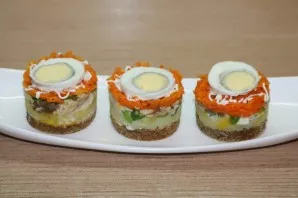 Put a sliced egg on top of a layer of carrots.