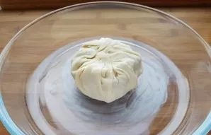 Fold the edges of the dough so that it completely covers the cheese. Transfer the cheese to a greased baking sheet.