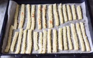 Put all the strips on a baking sheet. Brush the pieces of dough with a beaten egg or warm water and sprinkle abundantly with sesame seeds.