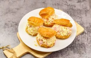 Cut each piece of dough lengthwise, but not completely. Fill with the prepared filling. Serve the appetizer.