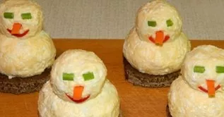 Now its time to decorate the snowmen. From green vegetables cut out the required number of eyes, nose and mouth.