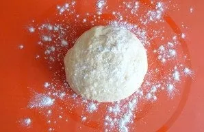 After the time has passed, place the dough on the work surface. Dust lightly with flour.