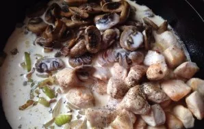 Add fried mushrooms and chicken to onions, pour everything with cream and add spices.