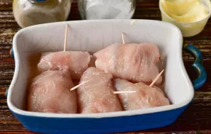 Roll the meat into rolls. Strengthen them with toothpicks and put them on a baking sheet.