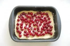 Wash the cherries, remove the dice. Sprinkle the dough with starch, lay out the cherries. Starch will absorb cherry juice.