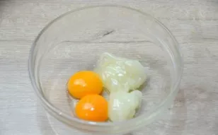 Add 2 tablespoons of starch mass from the pot to the yolks. Stir well until smooth.