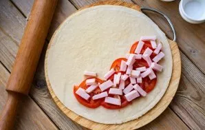 Cut the ham into small cubes or sticks and put half on the tomatoes.