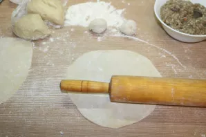 Next, divide the dough into four parts and each part into four more. Thinly roll out each part of the cheburek into a circle.