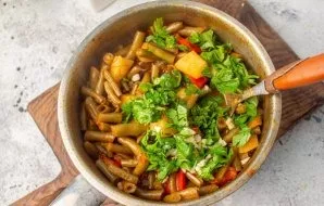 Remove the cooked stew from the stove. Add finely chopped herbs and garlic.