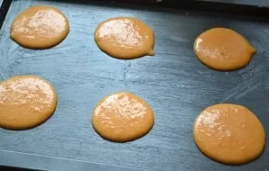 Grease a baking sheet with pork fat and at a distance of about 2 cm from each other pour small circles of dough.