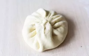 Raise the edges of the dough upwards and pinch with your fingers to form a bag with cheese filling inside.