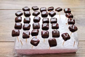 Chop the chocolate and melt it in a water bath. On the toothpicks, roll the candies from the bottom and, leaving the top, immerse them in...