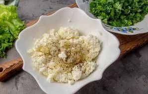 Squeeze the garlic through a press to the ricotta cheese, add salt and black pepper, mix.