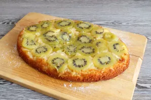 Sprinkle the dish or board with powdered sugar. Gently invert the cake onto a plate or board so that the fruit layer remains on top. Allo...