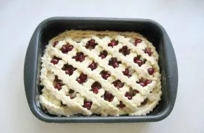 Roll out and the second part of the dough, cut out the strips. Place the strips on the cherries.