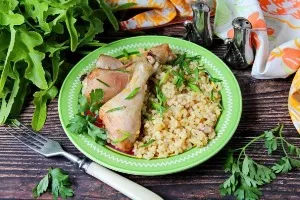 Chicken legs baked with bulgur in the oven